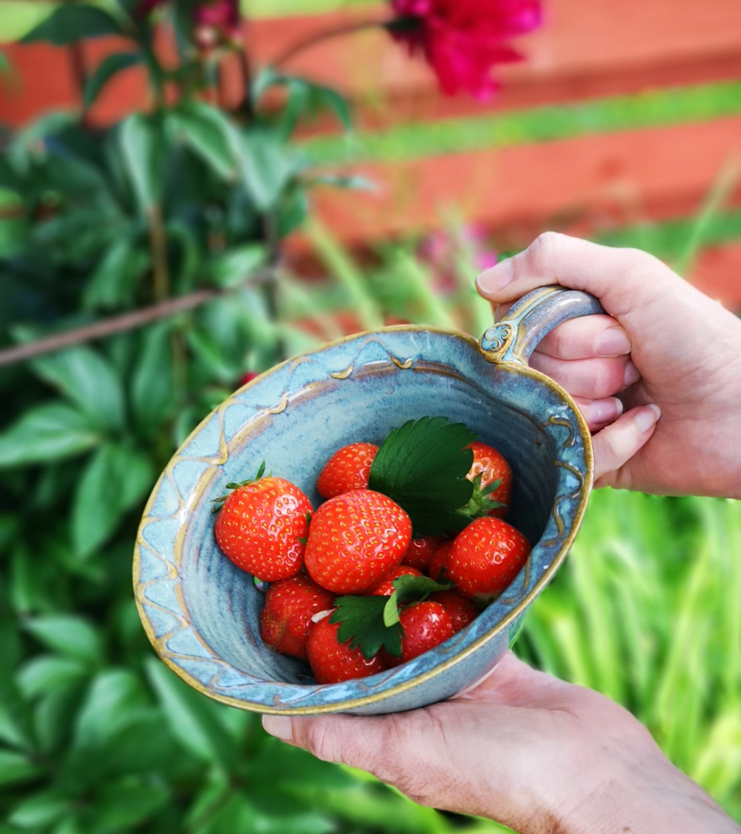 Berry Bowl with Drainage Holes in Green glaze with large handle. Strawberries in the garden. Made by Castle Arch Pottery